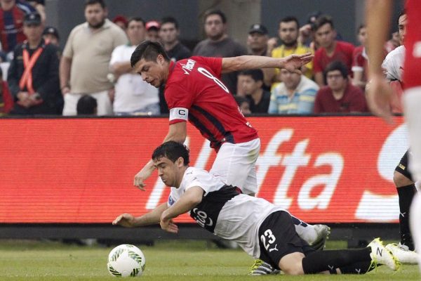 Julián Benítez, quien va al piso, sufre la marca de Rodrigo Rojas. Foto Gentileza APF.