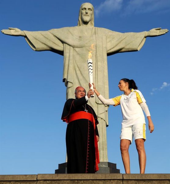 La exjugadora de voleibol brasileña, Isabel Barroso, entrega la antorcha olímpica al cardenal Orani Tempesta, en el Cristo Redentor, en Río de Janeiro, de Brasil. Foto Agencia EFE. 