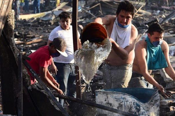 Personas vecinas del mercado de San Pablito ayudan a apagar las llamas tras la explosión. Foto Gentileza BBC Mundo. 