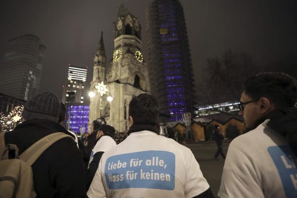 Varias personas con una camiseta en la que se puede leer 'Musulmanes por la Paz' se reúnen en las inmediaciones de la Iglesia Memorial Kaiser Wilhelm donde se oficia la misa por las víctimas. Foto EFE.